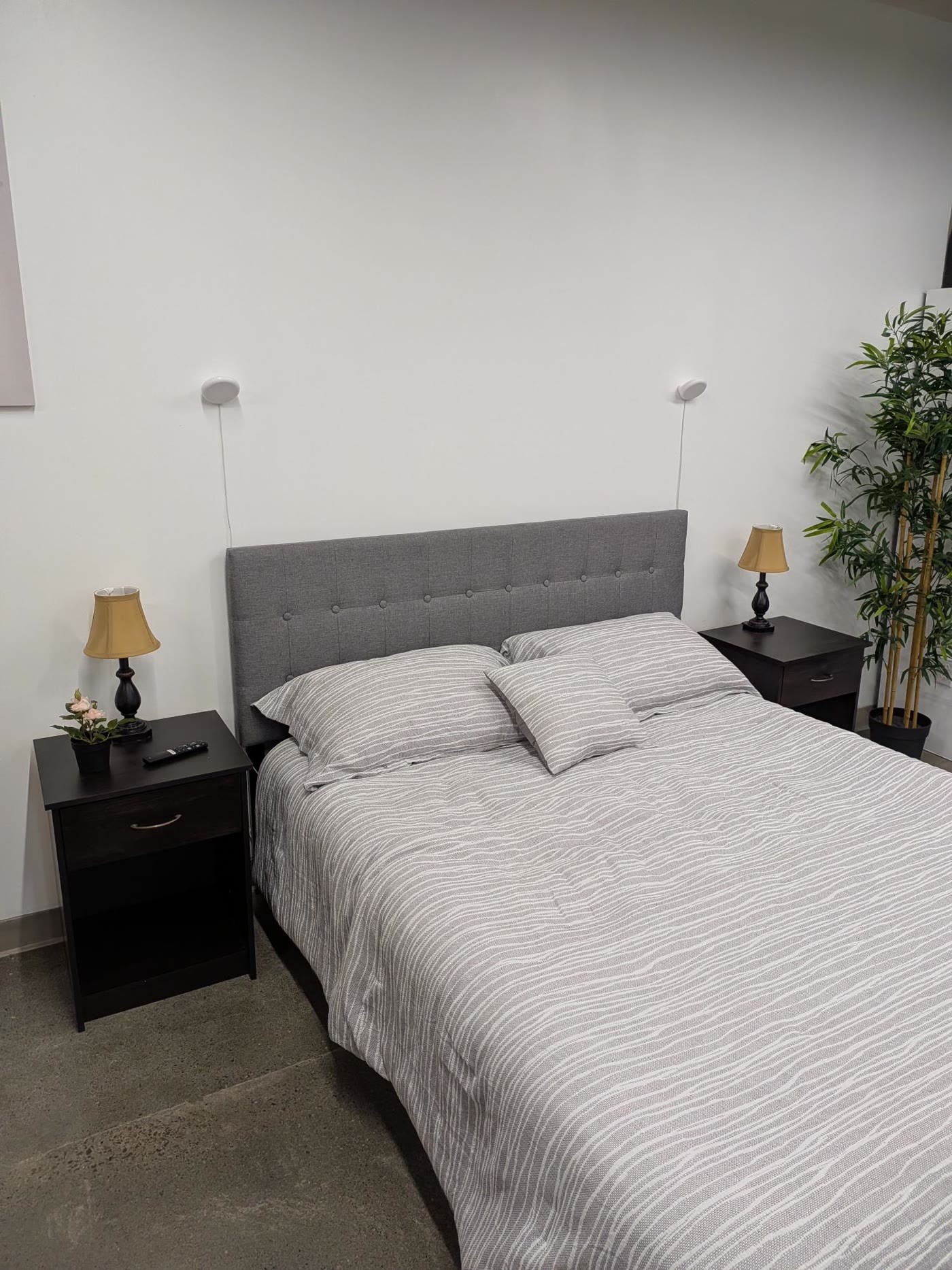 A made bed with two pillows and a duvet in a quiet bedroom