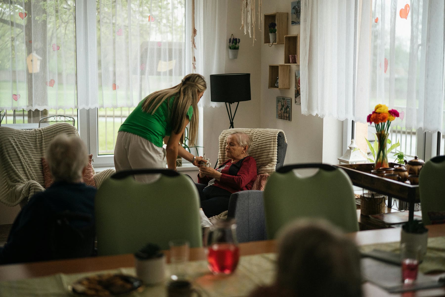 Older adults with a caregiver in a bright assisted-living lounge